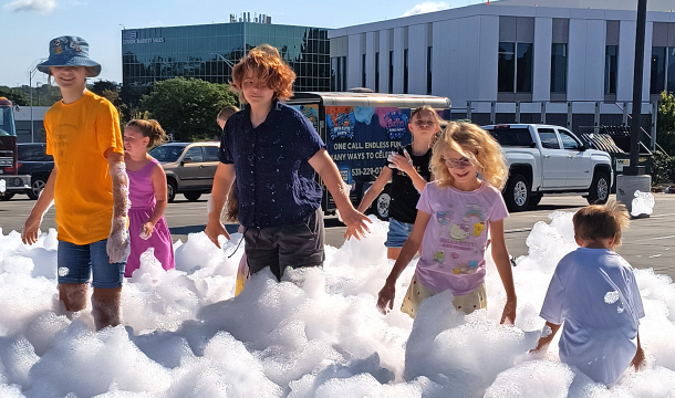 children playing in an area covered in a thick, bubbly foam