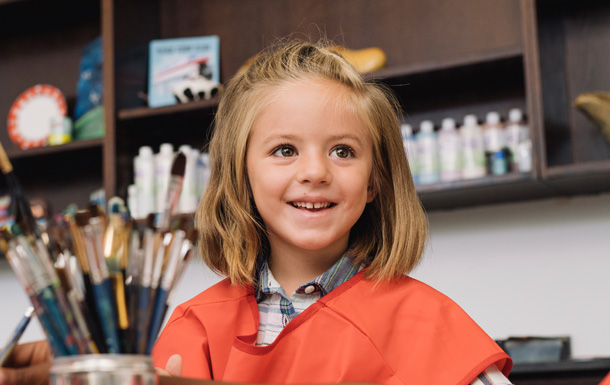 girl inside a paint studio smiling