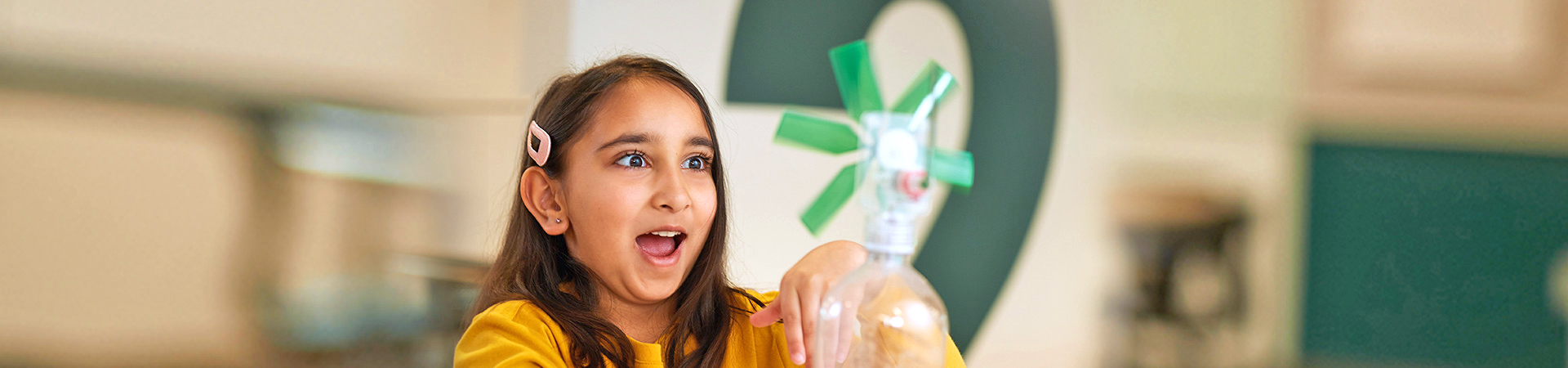  a young girl smiling at her stem propeller science experiment 