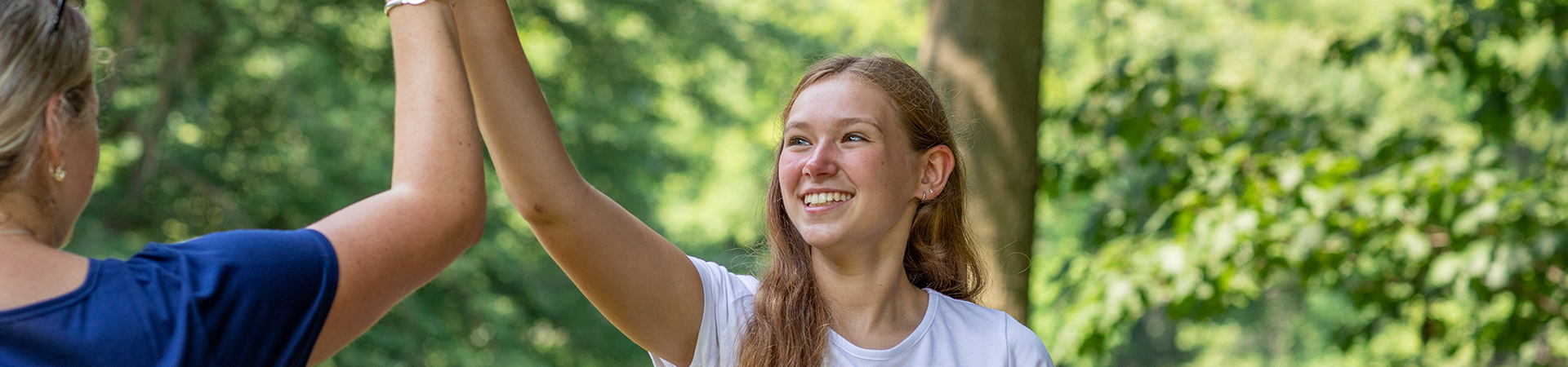  an older girl scout giving an adult volunteer a high five 